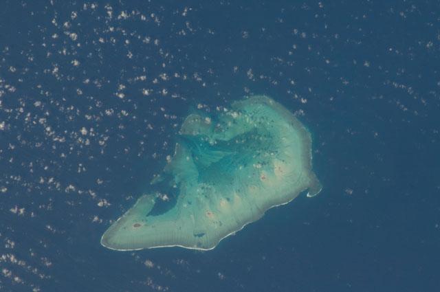 Ashmore Island (actually composed of three reef islets) is part of Ashmore Reef National Nature Reserve, which comprises several marine habitats, including seagrass meadows, intertidal sand flats, coral reef flats, and lagoons. 

This astronaut photo from 2011 shows that the reef making up the island is not continuous but has several breaks that allow for current and sediment inflow.

A memorandum of understanding between the Australian and Indonesian Governments allows Indonesian fishermen access to their traditional fishing grounds within the region, subject to limits. Image courtesy of NASA.