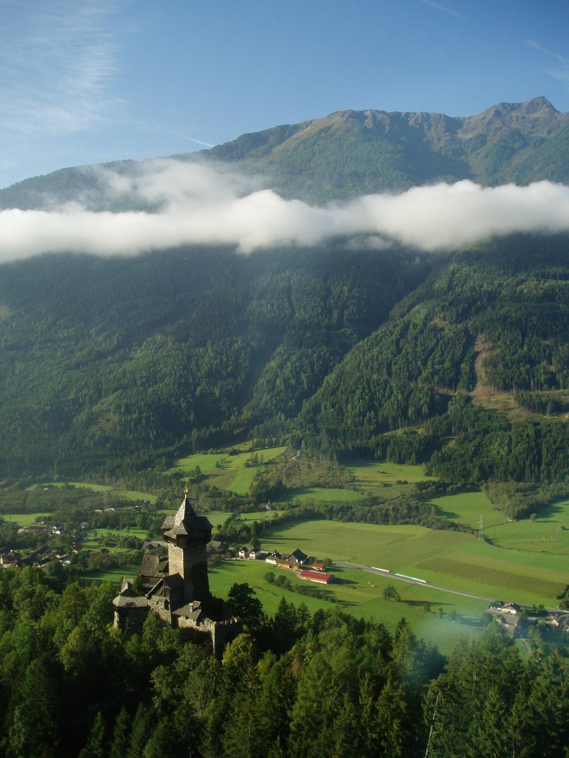 A castle and mountain valley in the Alps.