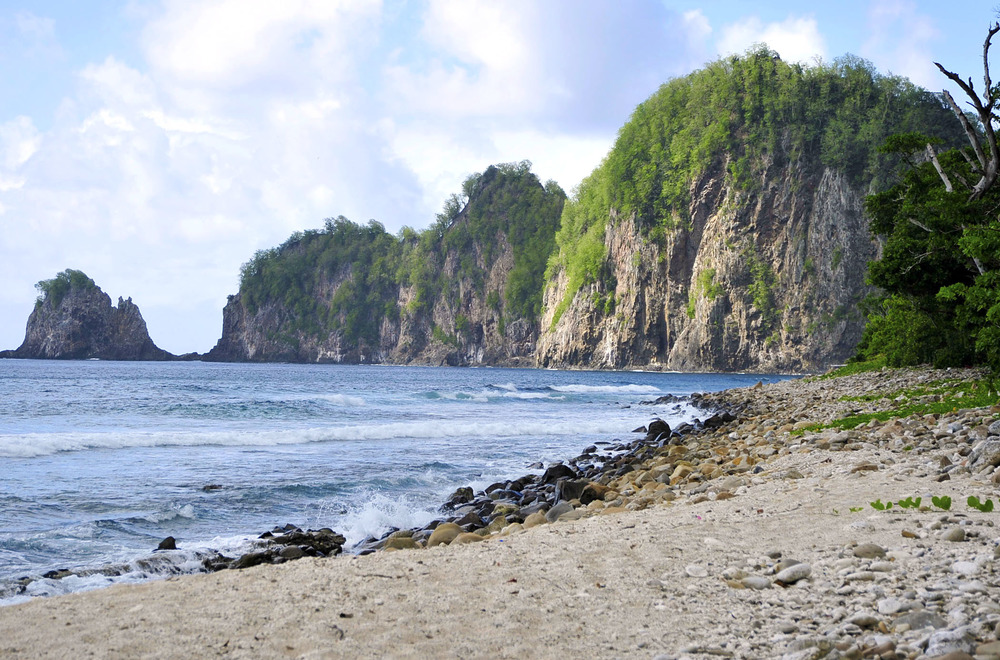 A quiet rocky beach at the end of the Tuafanua Trail on the north shore of Tutuila, looking out toward Pola Island. Photo courtesy of the US National Park Service.
