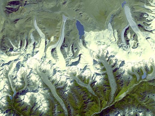 One of the highest mountain reliefs on Earth can be found in the tiny country of Bhutan. Sandwiched between eastern India and the Tibetan plateau, Bhutan hosts peaks that range between 5,000 and 7,000 m (16,000-23,000 ft) in height. These mountains are neighbors to Mount Everest, Earth's highest peak at 8,850 m (29,035 ft). The impressive Bhutan Himalayas are permanently capped with snow, which extends down valleys in long glacier tongues. Because of disparate weather patterns on either side of the Himalayas and differences in topography, the glaciers on each side of the mountain are distinctly different from one another and are likely to react very differently to climate change. Image courtesy of NASA.

