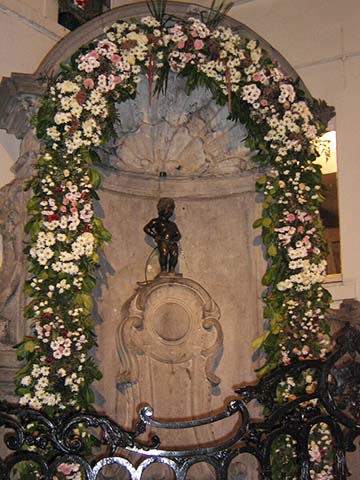Manneken Pis is a landmark 61 cm (24 in) bronze fountain sculpture in the center of Brussels, depicting a naked little boy urinating into the fountain's basin. Erected in 1618 or 1619, the current statue is a replica that dates from 1965. The original is preserved in the Brussels City Museum. While Manneken Pis is one of the best-known attractions of Brussels, many tourists are taken aback by its small size. 