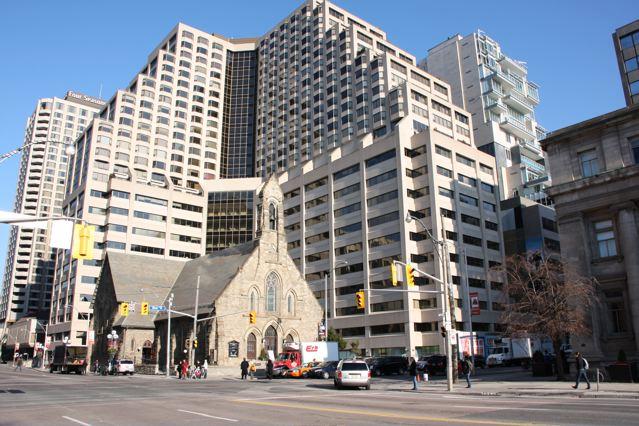 The historic Church of the Redeemer on the northeast corner of Bloor St. and Avenue Rd. in Toronto was completed in 1879. It is dwarfed by the massive Four Seasons Renaissance Centre. 
