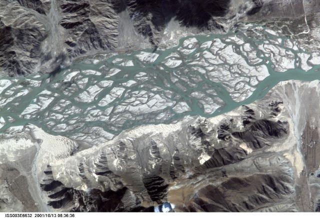 The Brahmaputra River carves a narrow west-east valley between the Tibetan Plateau to the north and the Himalaya Mountains to the south, as it rushes eastward for more than 1,500 km (940 mi) in southwestern China. This 15-km (9-mi) stretch is situated about 35 km (22 mi) south of the ancient Tibetan capital of Lhasa where the river flow becomes intricately braided as it works and reworks its way through extensive deposits of erosional material. Click on photo for higher resolution. Image courtesy of NASA.
