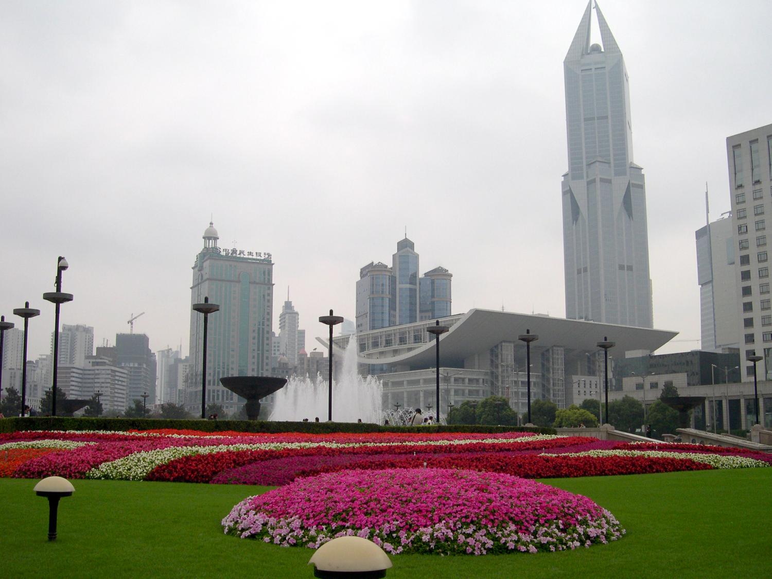 The Grand Theater in Shanghai, the largest city in China with over 20 million citizens. Shanghai was a multinational hub of finance and business in the 1930's before its development and prosperity were set back by half a century of Communism. Economic reforms of the 1990s revitalized the city. Today it is the largest center of commerce and investment in China, as well as a popular tourist destination. The distinctive tall building in the background, Tomorrow Square, houses a hotel and apartment units.