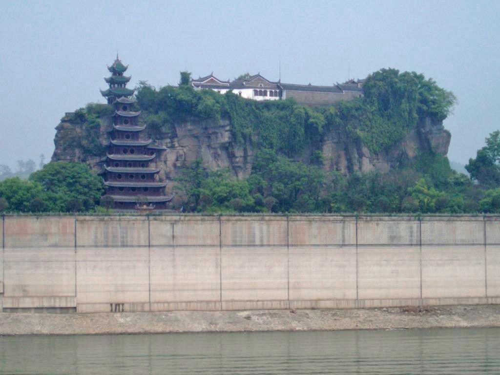 Shibaozhai is a steep, rocky, and craggy hill on the bank of the Yangtze River, in Zhong county, Chongqing. A temple at the crest of the 220 m (722 ft) hill was built in the 18th century. A nine-story wooden pagoda was constructed in the 1819 to aid pilgrims in getting to the top of the hill. In 1956, three more stories were added.  A coffer dam protects the site from higher river waters - the result of the Three Gorges Dam. 