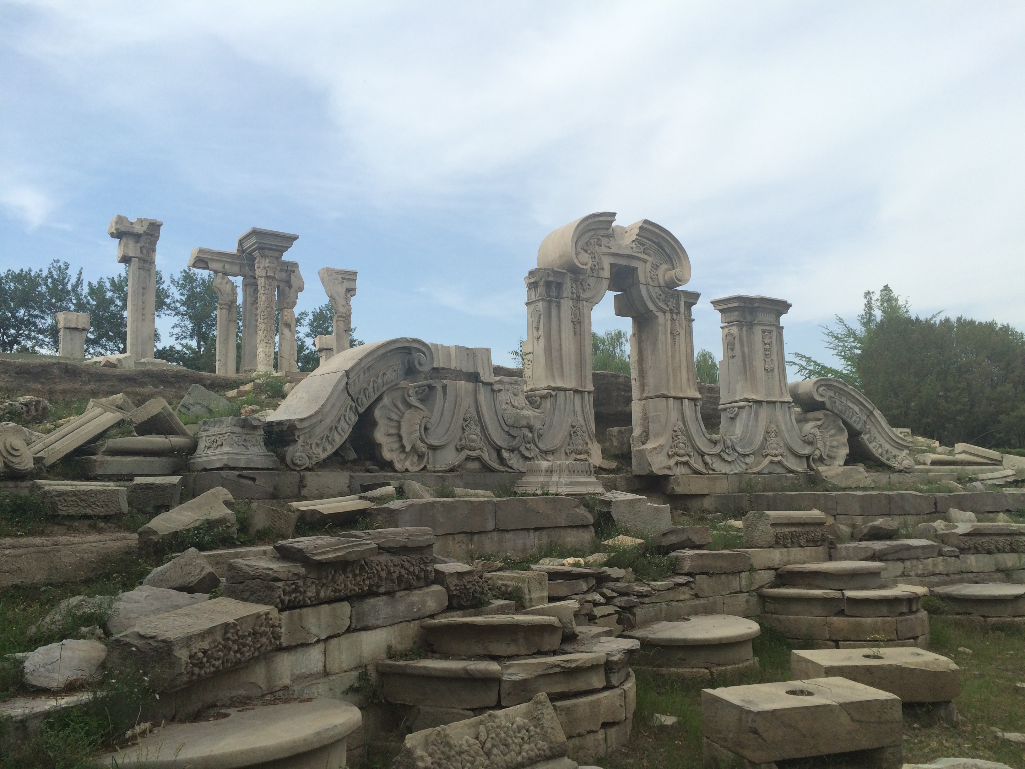Ruins of the European-style palaces at the Old Summer Palace, 8 km (5 mi) northwest of the Imperial City section of Beijing. The complex of palaces and gardens was originally referred to as the Imperial Gardens. Constructed throughout the 18th and early 19th centuries, the Old Summer Palace was the main imperial residence of the emperor and where he handled state affairs; the Forbidden City was used for formal ceremonies. Widely perceived as the pinnacle of Chinese imperial garden and palace design, the Old Summer Palace was known for its extensive collection of gardens, its building architecture, and numerous art and historical treasures. Referred to as a "Garden of Gardens," it was destroyed in 1860, during the Second Opium War.