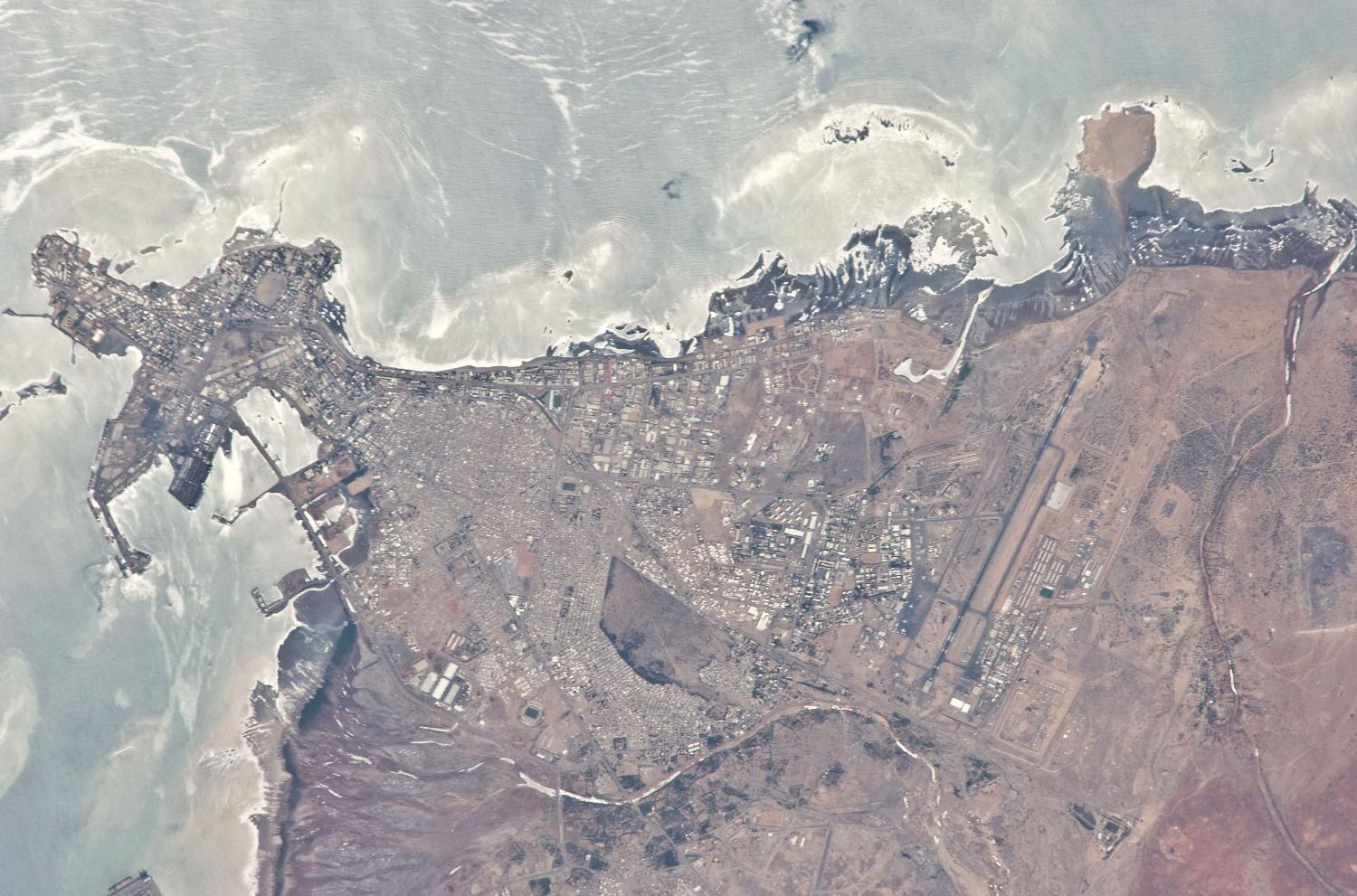 Djibouti City is the capital and largest city in Djibouti. Two thirds of the country's population lives in this seaport, which is situated on the Gulf of Tadjoura on the western side of the Gulf of Aden. The city is the cultural and industrial center of Djibouti and has the status of both a city and a state. Local features include beautiful sandy beaches along its eastern shore (top). The landscape around the city, along with Djibouti's coastal lowlands, is desert or semi-desert. Image courtesy of NASA. 