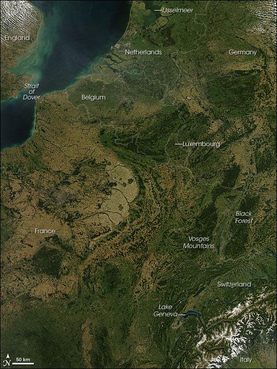 A rare cloud-free view of a wide area of Western Europe. This Aqua satellite image was captured on 30 August 2008. Skies were clear from the Netherlands in the north to Italy in the south, revealing several of Europe's famous natural and man-made features. A few small fires (marked with red dots) were detected, as well. 

A pair of geologically matching mountain ranges appear at the border of France and Germany, covered in dark green forests. France's Vosges and Germany's Black Forest rise on either side of the Rhine River Valley. The valley in that area is known to geologists as the Rhine Graben; a graben is an elongated block of Earth's crust that has sunk relative to surrounding blocks. To the south, the snow-covered Alps create an arcing boundary between Switzerland and Italy.

Near the bottom right of the image, one of the largest lakes in Europe, Lake Geneva (formally known as Lac Leman), fills a glacier-carved valley in western Switzerland. This natural lake occurs on the Rhone River, upstream of where it makes a sharp southward bend as it leaves the Alps. At the northern edge of the image is a larger, artificial lake: the Netherland's IJsselmeer. Despite its closeness to the North Sea, IJsselmeer is a freshwater lake. It was originally a saltwater inlet at the mouth of the IJssel River, but in the early 1930s, the Dutch built a dike across the inlet. The freshwater flow of the IJssel River flushed out the seawater, forming the new lake. Photo courtesy of NASA.