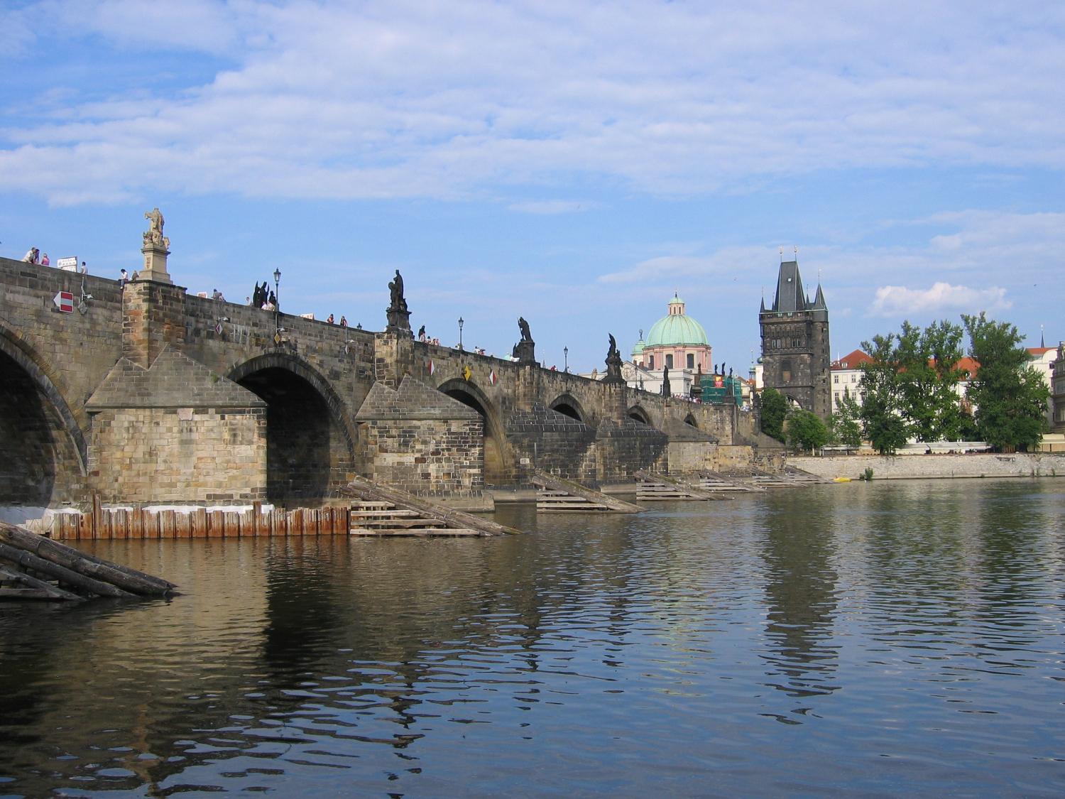 A riverside view of Charles Bridge in Prague showing the ice guards that protect the pillars. 