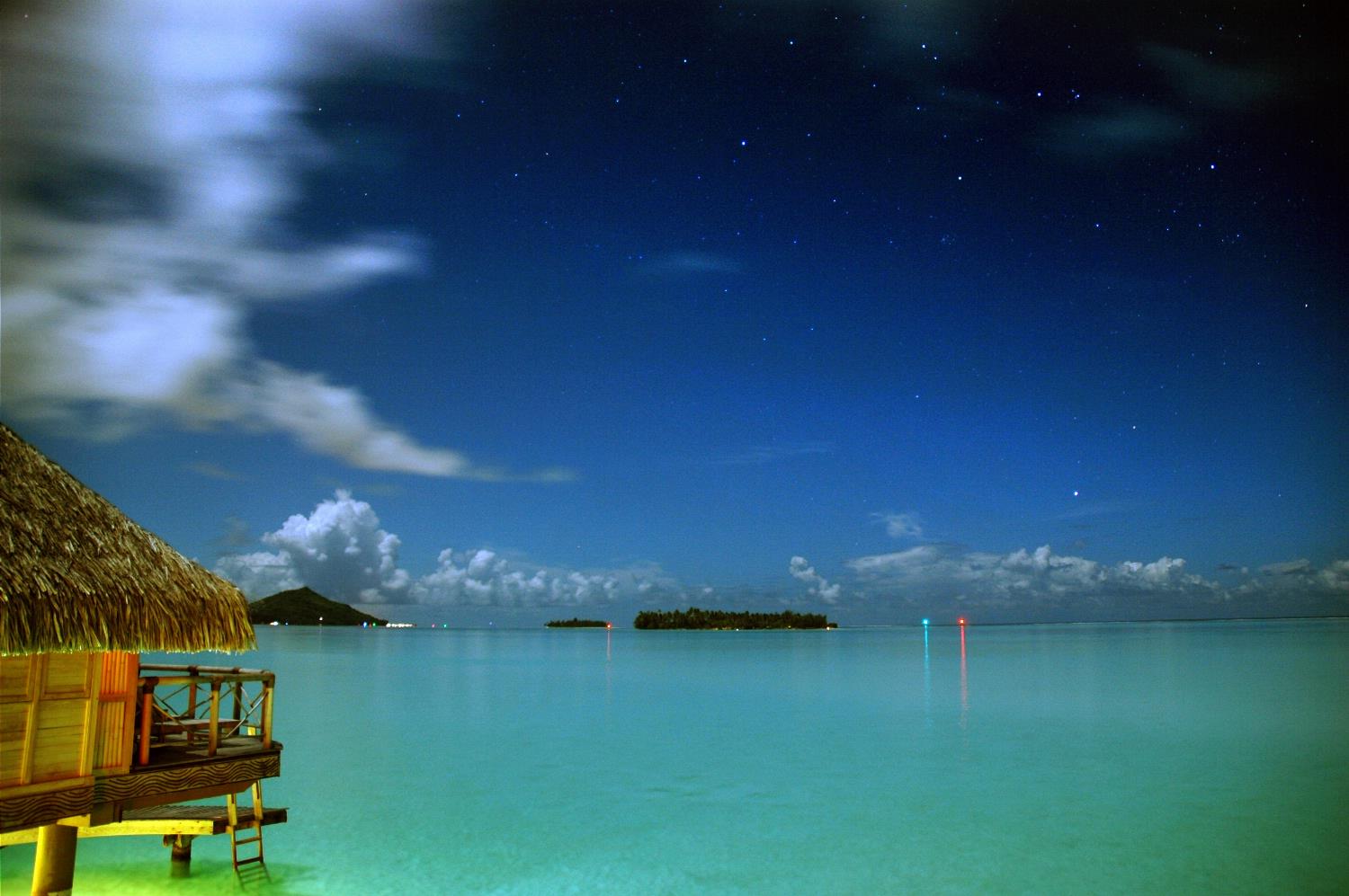 Nightfall over an over-water bungalow in Bora Bora.