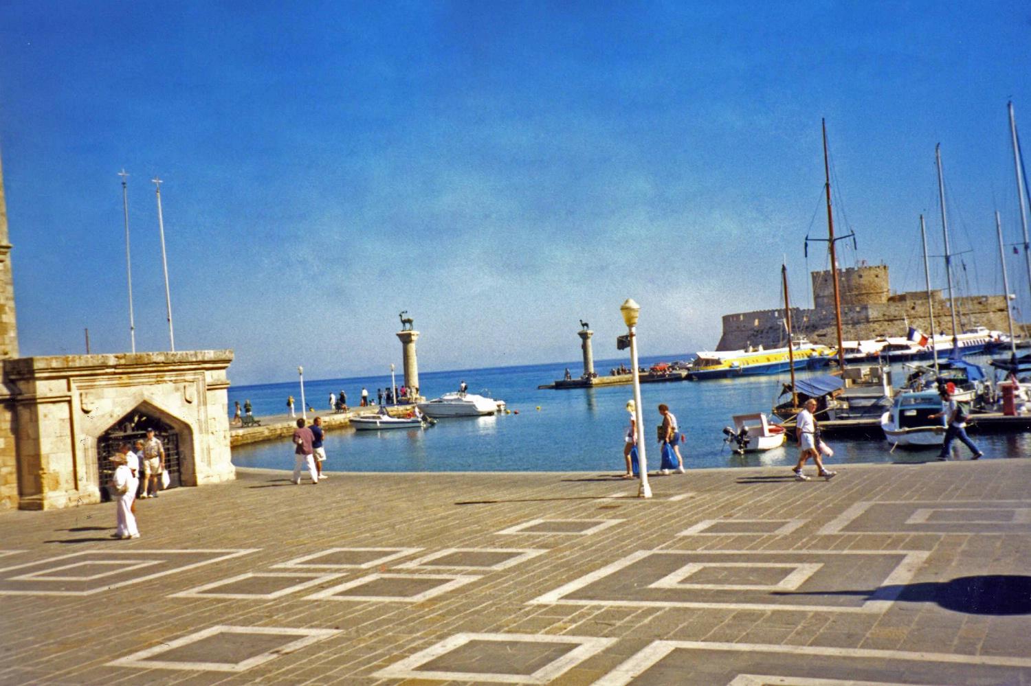 Mandraki Harbor at Rhodes, the site of a third century B.C. statue to the Greek sun god, Helios. Standing some 30 m (100 ft)  high, it became known as the Colossus of Rhodes, and was considered one of the Seven Wonders of the Ancient World.