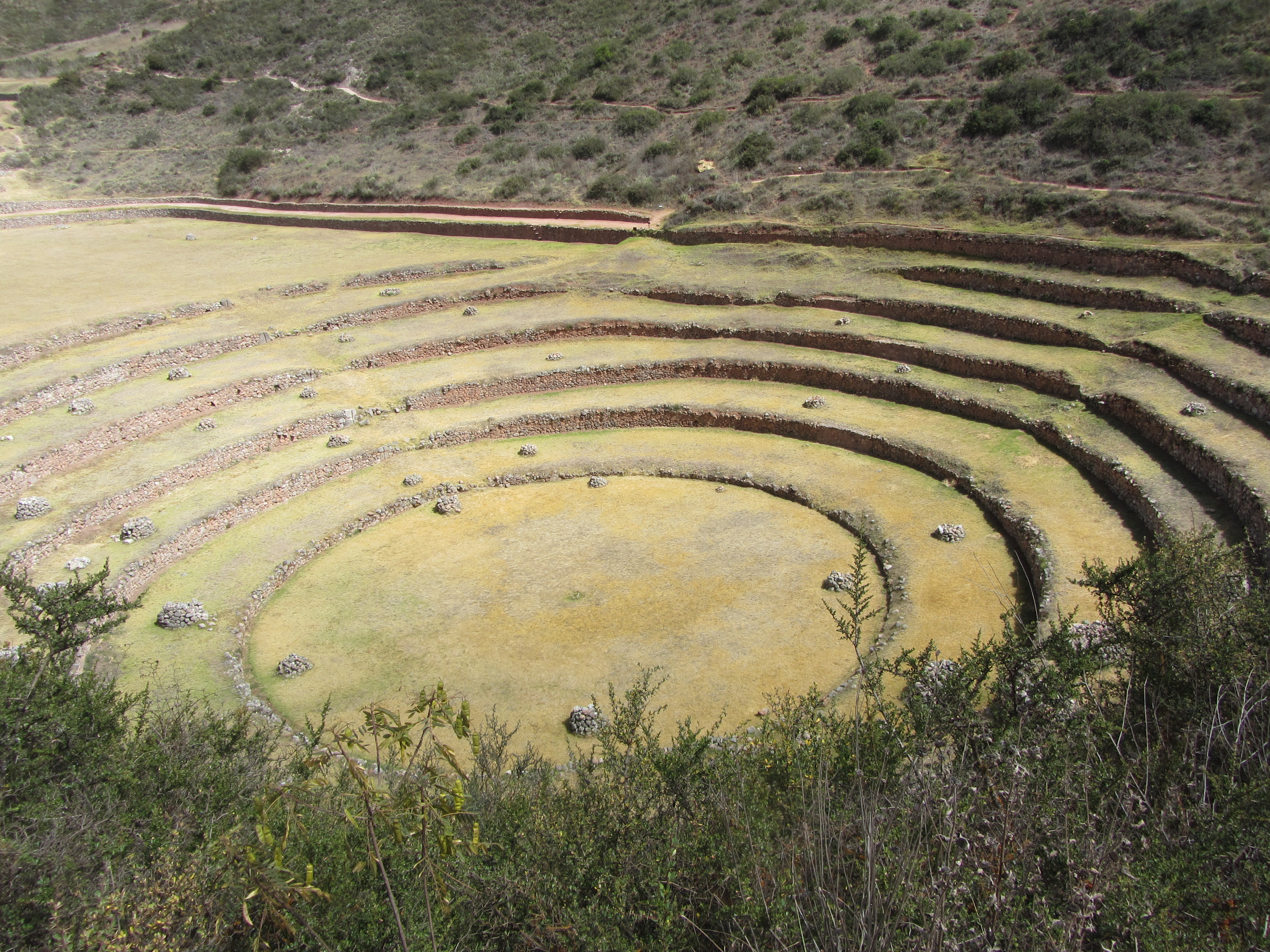 This huge series of concentric terraces in Moray (just west of the salt pans of Maras) served as an ancient agricultural research station. The distance from the highest to lowest ring is 150 m (490 ft), which allowed the Wari and later the Inca peoples to experiment with growing crops at different altitudes and exposure to the sun. The circular bottom is so well drained that it never completely floods, no matter how hard the rain. 