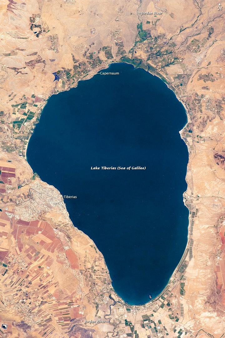 Israel's largest freshwater lake, Lake Tiberias, is also known as the Sea of Galilee. The lake measures just over 21 km (13 mi) north-south, and it is only 43 m (141 ft) deep. The lake is fed partly by underground springs related to the Jordan sector of the Great Rift Valley, but most of its water comes from the Jordan River, which enters from the north. The river's winding course can be seen draining the south end of the lake at image bottom. Angular green and brown field patterns clothe most hillsides in this arid landscape. Bright roof tops are the hallmark of several villages in the area. Much of the area to the east of the lake is part of the Israeli-occupied Golan Heights. Image courtesy of NASA.