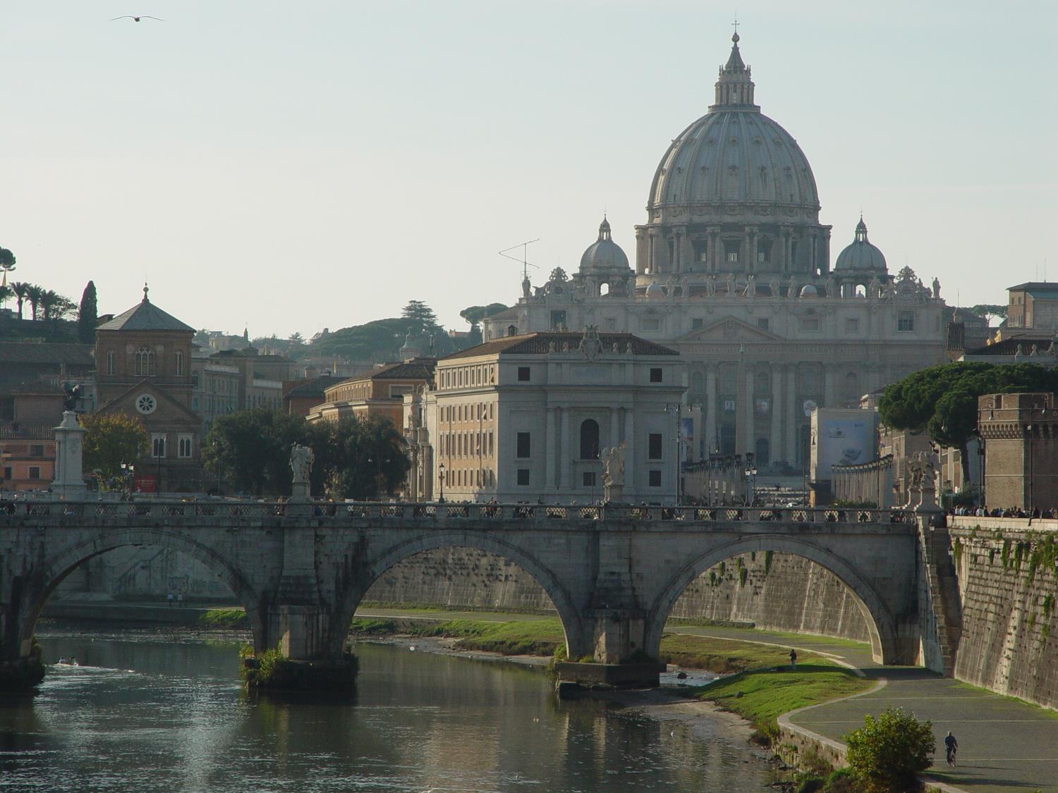 The Vittorio Emanuele Bridge over the Tiber River in Rome with Vatican City (and St. Peter's Basilica) in the background. 