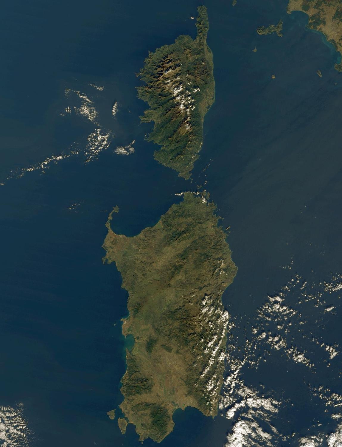 Rich in antiquities and picturesque landscapes, the island provinces of Corsica, France, (top) and Sardinia, Italy, (bottom) have captured the imaginations of historians and poets alike for centuries. Corsica, crowned with snow-capped mountains, jeweled with shimmering lakes, and cloaked in misty emerald forests, is situated in the Mediterranean Sea southeast of mainland France. The island has almost 1,700 hills and mountains, and is carved by an extensive network of rivers. Across the Strait of Bonifacio to the south is Sardinia, the Mediterranean's second largest island. Stretching across the central, eastern part of Sardinia is the rugged terrain of Gennargentu - mountainous, thickly vegetated, and mostly uninhabited. The port city of Cagliari sits on the large bay on Sardinia's southern coast. Photo courtesy of NASA. 