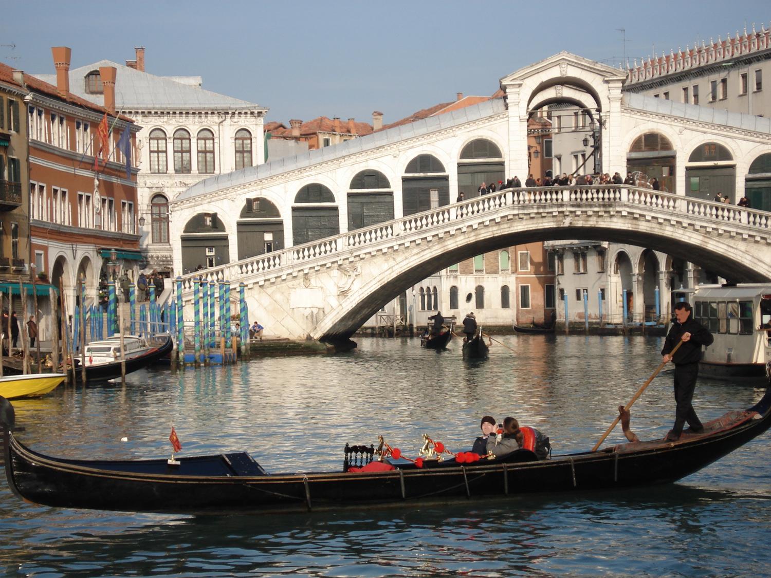 The Rialto Bridge was one of the first bridges to span the Grand Canal in Venice allowing residents to access the Rialto Market. The structure was originally constructed of wood, but after it collapsed twice under the weight of residents watching boat races, it was replaced by a stone bridge in 1591. 