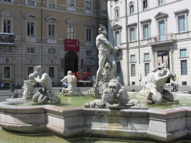 La Fontana del Moro (The Fountain of the Moor) at the south end of the Plaza Navona in Rome shows a Moor wrestling with a dolphin surrounded by four tritons. The fountain and tritons were executed by Giacomo della Porta in 1575.  The statue of the Moor by Gian Lorenzo Bernini was added in 1653.  The originals of the figures were moved to the Villa Borghese in 1871.