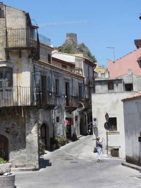 Street scene in Savoca with an Arab watch tower in the background.
