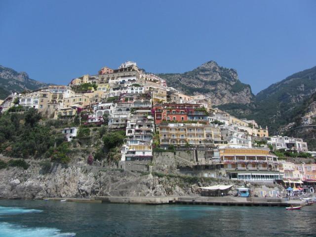 View of homes in Positano on the rugged Amalfi Coast. The city is about 18 km east of the city of Amalfi. It was a prosperous port of the Amalfi Republic during the 16th and 17th centuries. Most of the population emigrated in the 19th century, mainly to Australia. In the 1950s, the town began to become popular with artists and writers. Tourists began to arrive in the mid 1950s in large numbers. The city and area are famous for the liqueur Limoncello.
