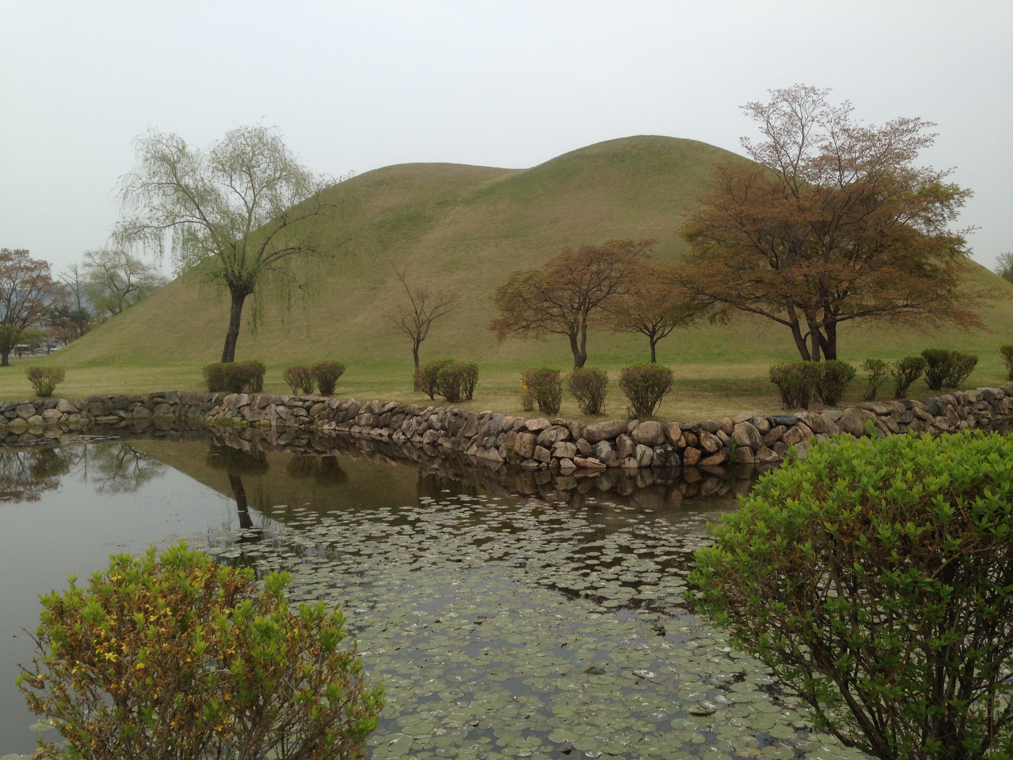 Daereungwon Tomb Complex (Tumuli Park) in Gyeongju.  Lasting almost 1000 years (57 BC – AD 935), the Silla dynasty in Korea was one of the longest in recorded history, and the people of that time revered their dead through the erection of tumuli. The largest mounds were, of course, for royalty, and the Daereungwon Tomb Complex in the ancient capital city Gyeongju provides an opportunity to walk around and even inside one of these incredible structures. Five tombs on these grounds are believed to include the founder of the Silla Kingdom,  King Baehyeokgeose, his queen Aryeong, and three of the next four kings of Silla.