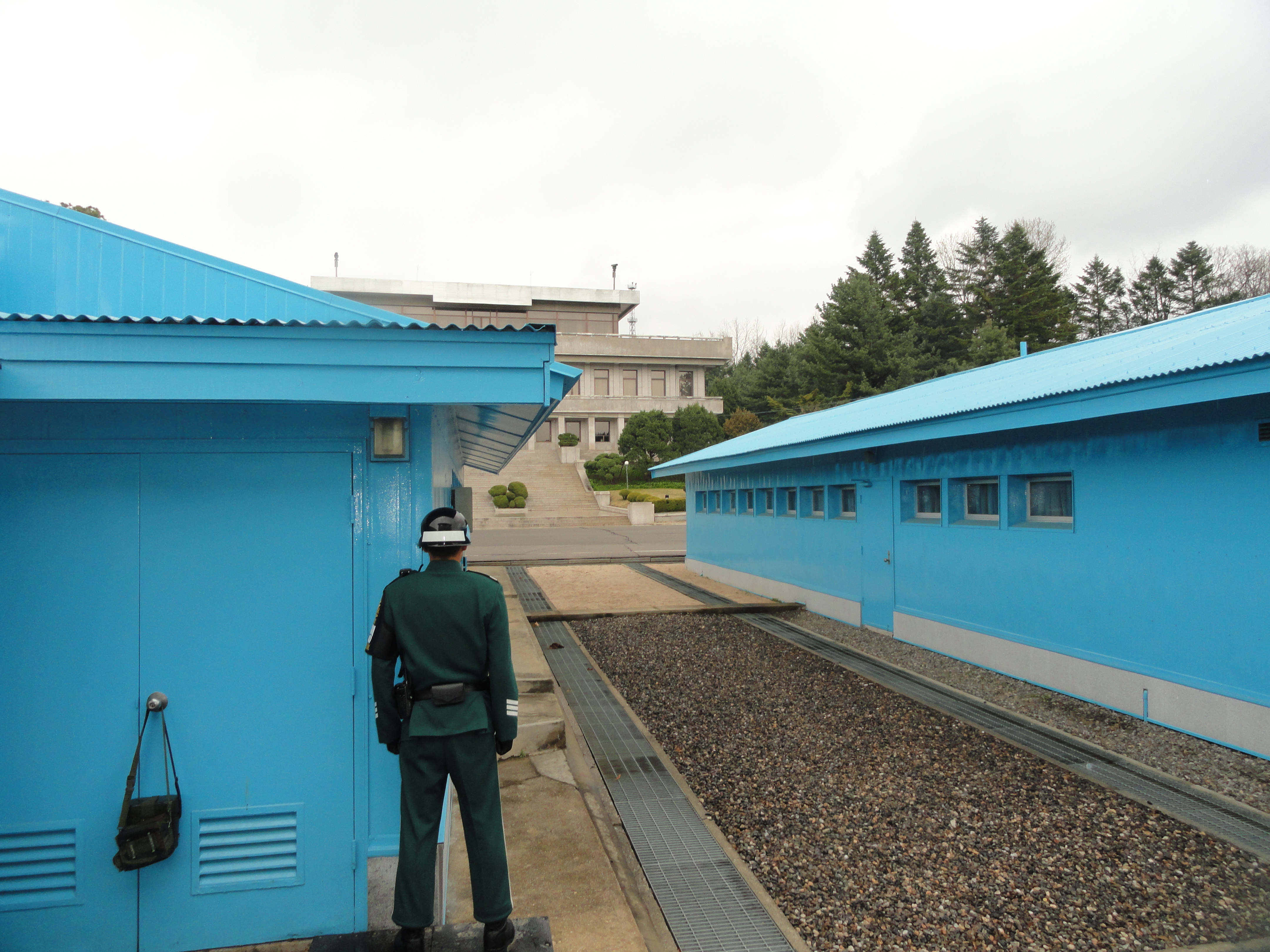 A view of the area between UN buildings in the JSA. The gray gravel section is South Korea and the light brown half is North Korea. The brick ledge is the actual physical border mark in the security area.