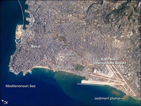 Beirut, Lebanon's capital, is built on a small peninsula; the growth of the city eastwards is bounded by foothills of the more mountainous interior of Lebanon (upper right). Beirut has been an urban center for 5,000 years. Throughout much of that time, the city has been the focus of both military and economic conflicts among neighboring city-states. Distinctive features visible in this astronaut photograph include the Rafic Hariri International Airport in the lower right, the city sports arena at image center, and several areas of green and open space, including a large golf course at image center. Also visible in the photo are several plumes of sediment along the coastline; the most striking plumes are near the airport. The general lack of vegetation in the airport may allow more soil transport by surface water runoff or wind. Photo courtesy of NASA.