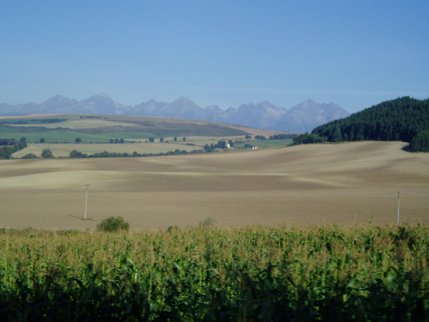 The Slovakian countryside, with the Tatra Mountains visible in the distance. The Tatras are the highest mountain range in the Carpathian Mountains and form a natural border between Slovakia and Poland. About 78% of the Tatras lie within Slovakia as does the highest peak, Gerlachovsky Stit, at 2,655 m (8,710 ft).
