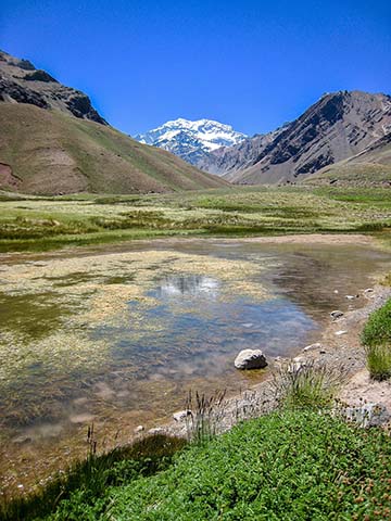 A view of Laguna de Horcones at 2,950 m in Parque Provincial Aconcagua, Mendoza, Argentina. Snow covered Aconcagua, the largest mountain in the Western Hemisphere at 6,962 m, stands prominently in the background. 