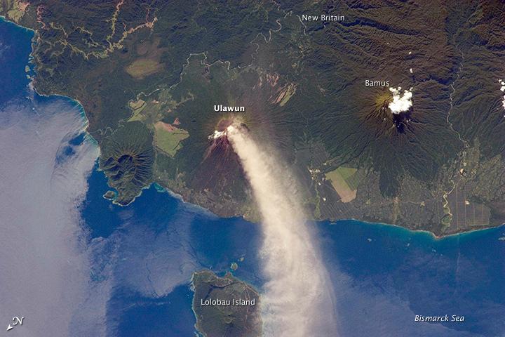 Numerous volcanoes contribute to the landmass of the island of New Britain, the largest in the Bismarck Archipelago of Papua New Guinea. One of the most active of these volcanoes - Ulawun - is also the tallest, with a summit elevation of 2,334 m (7,657 ft).

This astronaut photograph shows a plume of white steam and ash extending from the summit crater of the stratovolcano towards the northwest. The plume begins to broaden as it passes the southwestern coast of Lolobau Island, approximately 23 km downwind. Note that north is towards the lower left.

Ulawun is also known as "the Father," with the Bamus volcano to the southwest also known as "the South Son." The summit of Bamus is obscured by white cumulus clouds (not of volcanic origin) in this image. While Ulawun has been active since at least 1700, the most recent activity at Bamus occurred in the late 19th century. A large region of ocean surface highlighted by sunglint - sunlight reflecting off the water surface - is visible to the north-northeast of Ulawun. Photo courtesy of NASA.