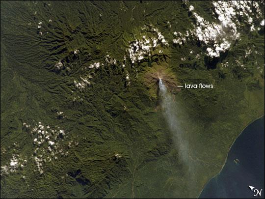 Although Bouganville Island is geographically part of the Solomon Islands chain, politically, the island is part of Papua New Guinea. Bouganville is typical of many Pacific Rim islands in that volcanism has played a large part in both its geological and recorded history. The island hosts three large volcanoes along its northwest-southeast trending axis: Mount Balbi, Mount Bagana, and the Mount Takuan volcanic complex. Mount Bagana, located near image center in this astronaut photograph, is the only historically active volcano on the island.

Within Bouganville's lush landscape, light green vegetation and brown lava flows mark the 1,750-meter-high lava cone of Mount Bagana. The lighter color of vegetation could result from volcanic activity, higher altitude, or both. The eruptive style of the volcano is typically non-explosive, producing thick lobes of lava that run down the flanks and maintain a dome in the summit crater. Occasional pyroclastic flows of rock fragments and volcanic ash have also occurred. This image shows a diffuse white vapor plume extending west-southwest from the summit. Photo courtesy of NASA.