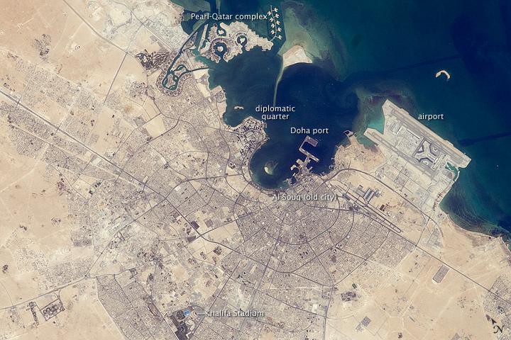 The old and new zones of Doha, the capital city of Qatar, are clearly visible from the International Space Station. The old city comprises the ancient bazaar, or Souq, near the dhow harbor, which is still used today for traditional Arab sailing vessels. Modern port facilities have sprung up to the east of the Souq.

Subsequent developments have sprouted progressively further from the ancient center, with ring roads concentrically arranged around it. The diplomatic quarter is reached via the waterfront Corniche promenade, north of the old city. Further away, an extensive marina known as West Bay Lagoon, with boating access to the Persian Gulf, stands out (image top).

Qatar's new artificial island, known as the Pearl-Qatar, is under construction with 32 km of new coastline just offshore of West Bay Lagoon. This development is intended mainly as a residential zone, with themes based on Arabic, Mediterranean, and European cultures. The Pearl-Qatar is so named because it is being built on one of Qatar's historical pearl diving sites. A string of small islands built along the outer margin is intended to recall the pearl-diving culture of the nation's past. Image courtesy of NASA.