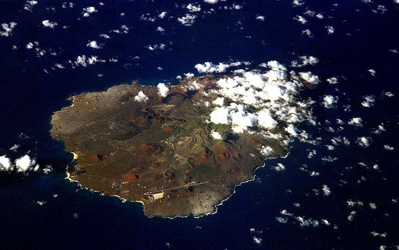 An oblique view of rugged Ascension Island, which is is barren in many places and has no indigenous human population. Instead the residents of the island are there because of Ascension's main industry: communications. The island has a long history as a communications hub for telephone and radio communications and as a base for satellite tracking stations, including a NASA station built in the 1960s that no longer operates. The European Space Agency operates a tracking station for its Ariane spacecraft on the eastern side of the island. 

Ascension Island is one of the most important breeding grounds for seabirds in the tropical Atlantic Ocean. The population of seabirds has been under threat since the first humans sailed up to the island in the 1500s. The ships accidentally introduced black rats, which overran the island, until cats were introduced to curb the rat population. The feral cats have decimated the bird populations, and in fact, are probably responsible for the extinction of two of the islands native land birds. A restoration project is underway to control the cat population and revive the seabirds. Image courtesy of NASA.