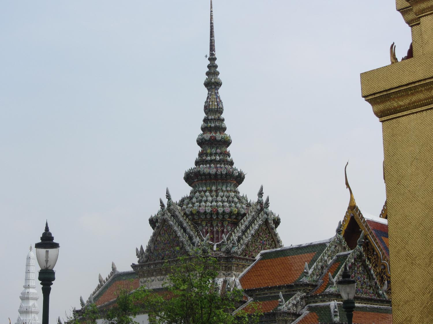 The Grand Palace is a complex of buildings in central Bangkok on the banks of the Chao Phraya River. Construction of the Grand Palace began in 1782 and it served as the official residence of the king and the royal family until 1925. It is still used for official events. Several royal offices are housed on the palace grounds. Shown in this view is the amazingly detailed floral roof of Chakri Maha Prasat Hall.