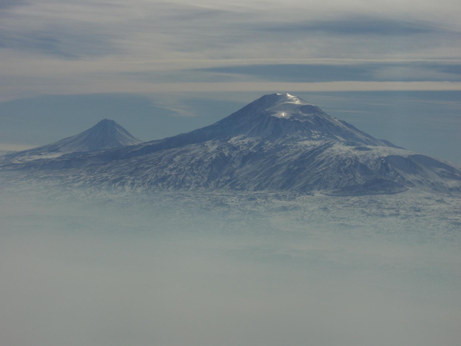 A view of Mount Ararat in eastern Turkey through the fog. The highest of its two peaks, Greater Ararat, is the tallest mountain in Turkey at 5,166 m (16,949 ft). Although located some 32 km (20 mi) from the Armenian border, the dormant volcano dominates the skyline of Yerevan, Armenia's capital. This photo was snapped after take off from the Yerevan airport.