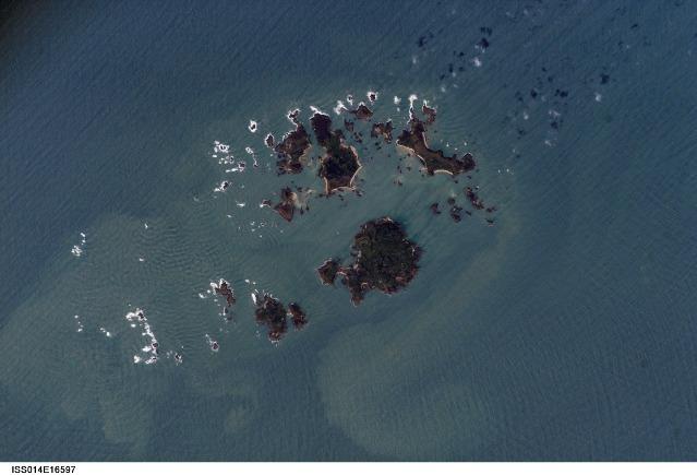 The Isles of Scilly, an archipelago of approximately 150 islands, are located some 45 km (28 mi) southwest of the westernmost point of England (Land's End). The islands are an erosional remnant of an ancient granite intrusion, and are notable because they have been inhabited for over 4,000 years. Only five of the islands are currently inhabited. Historical and geological evidence indicates that many of the islands were larger and/or connected in the recent past. Even today, it is possible to walk between certain islands during low tides. Image courtesy of NASA.