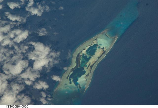 Palmyra Atoll is an unoccupied equatorial Northern Pacific atoll of some 12 sq km (4.6 sq mi) administered by the US Government. It is located almost due south of the Hawaiian Islands, roughly halfway between Hawaii and American Samoa. The atoll consists of an extensive reef, two shallow lagoons, and some 50 sand and reef-rock islets and bars covered with vegetation. The variable temporary population of 4 to 20 "non-occupants" consists of staff and scientists employed by various departments of the US Government and The Nature Conservancy, as well as a rotating mix of Palmyra Atoll Research Consortium scholars pursuing research. Photo courtesy of NASA.