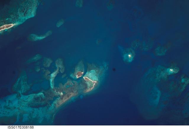 The Dry Tortugas are a group of islands located some 120 km (75 mi) west of Key West, Florida; they form the western end of the Florida Keys in the Gulf of Mexico. Like the Keys, the Dry Tortugas are formed primarily of coral reefs over older limestone formations. The islands were named "Dry Tortugas" upon discovery by Ponce de Leon in 1513 - "tortugas" means turtles in Spanish, and the islands are "dry" as no fresh water is found on them. Accessible only by boat or seaplane, the islands nevertheless have been designated a national park and are visited by hundreds every year. This view highlights three islands in the group: Bush Key, Hospital Key, and Garden Key - the site of hexagonal Civil War-era Fort Jefferson. Image courtesy of NASA.