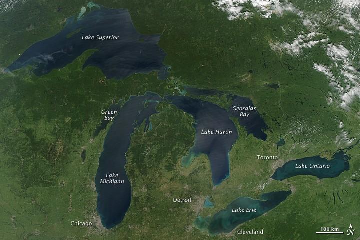 This image is a rare satellite view of a cloudless summer day over the entire Great Lakes region. The Great Lakes comprise the largest collective body of fresh water on the planet, containing roughly 18 percent of Earth's supply. Only the polar ice caps contain more fresh water. The region around the Great Lakes basin is home to more than 10 percent of the population of the United States and 25 percent of the population of Canada.
Open water appears blue or nearly black. The pale blue and green swirls near the coasts are likely caused by algae or phytoplankton blooms, or by calcium carbonate (chalk) from the lake floor. Photo courtesy of NASA.