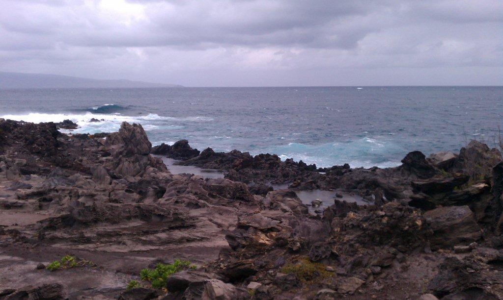 Kapalua Beach Trail on the island of Maui. The trail runs for 2.8 km (1.8 mi) along the Kapalua coast, passing white sand beaches, stunning homes, and lava flows, as shown in this picture.