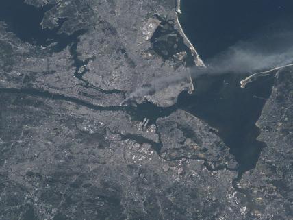 Visible from space, a smoke plume rises from the Manhattan area after two planes crashed into the towers of the World Trade Center. This photo was taken of metropolitan New York City (and other parts of New York as well as New Jersey) the morning of 11 September 2001. Image courtesy of NASA.

