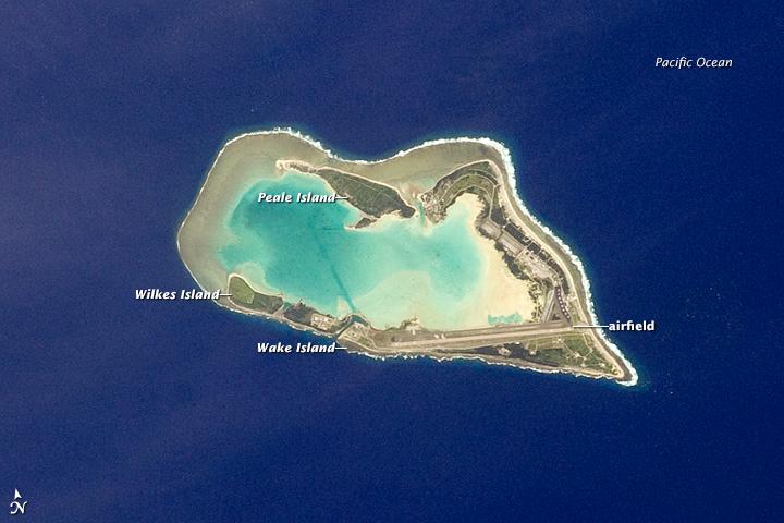 The atoll of Wake Island is composed of Wake Island proper and the smaller Peale and Wilkes Islands for a total land surface area of 6.5 sq km (2.5 sq mi). Like many atolls in the Pacific, the islands and associated reefs formed around a submerged volcano. The lagoon in the center of the islands marks the approximate location of the summit crater. Image courtesy of NASA.

