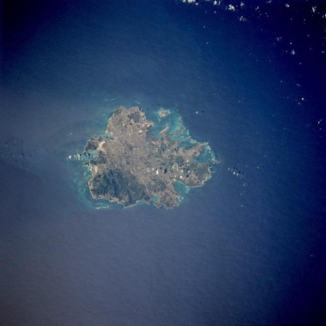 The island of Antigua shows severely eroded volcanic remnants along its forested southwestern quadrant. Although Antigua receives approximately 100 cm (40 in) of precipitation annually, wide fluctuations in rainfall amounts occasionally create serious water shortages, especially for the agricultural industry. St. John's, the country's capital, is located along the northwest coast, adjacent to one of the island's many natural harbors. More than half of the country's population lives in the St. John's area. Image courtesy of NASA. 