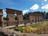Central wall of the huge two-story Inca Temple of Viracocha at Raqchi; the remains are some 100 m long and 14 m high. The original building consisted of a central adobe wall some 18 to 20 meters in height with a cut stone foundation base. Windows and doors allowed passage from one side to the other. The central wall was flanked on either side by a row of eleven columns. The foundations for both the wall and the columns were constructed of classic high Inca stonework with the remaining height built of adobe. (The 4 m height of the wall foundation survives, but most of the column heights have been reduced.) Prior to its destruction by the Spaniards, the temple had what was likely the largest single gable roof in the Incan Empire, with its peak at the central wall and stretching out over the columns on each side. The  site is at 3,480 m above sea level and 110 km from Cusco.