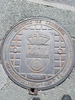 Town seal of Castro Urdiales on a manhole cover.