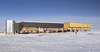 A view of the Amundsen-Scott South Pole Station. Even though built on stilts to prevent snow accumulation, some annual snow buildup does occur (about 20 cm (8 in) per year). The  station can be elevated to prevent its becoming buried in the snow. In the foreground is the ceremonial South Pole and the flags for the original 12 signatory nations to the Antarctic Treaty. Image courtesy of the National Science Foundation.