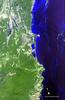 A view of the Belize Barrier Reef, the longest coral reef in the Western and Northern Hemispheres and second largest worldwide (after the Great Barrier Reef of Australia). Running the entire coastline of Belize in Central America, the Belize Barrier Reef supports a large number of patch reefs, shoals, and over 1,000 islands called "cayes." Most of these cayes, and the entire coastline of the country outside of settlements, are protected by huge forests of mangrove. The Turneffe Atoll is shown on the right side of the image. As one of three large coral atolls outside of the reef, it stretches over 48 km (30 mi) long and 16 km (10 mi) wide and is surrounded by one of the most fertile marine ecosystems in the world - a natural nursery for fish, sharks, and crocodiles. Belize City is situated on the outlet of land near the center of the image. It is the largest city in Belize and is the nation's principal port and its financial and industrial hub. Image courtesy of NASA.