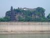 Shibaozhai is a steep, rocky, and craggy hill on the bank of the Yangtze River, in Zhong county, Chongqing. A temple at the crest of the 220 m (722 ft) hill was built in the 18th century. A nine-story wooden pagoda was constructed in the 1819 to aid pilgrims in getting to the top of the hill. In 1956, three more stories were added.  A coffer dam protects the site from higher river waters - the result of the Three Gorges Dam. 