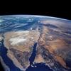 A view of the Sinai Peninsula and the Dead Sea rift area. The left side of the view is dominated by the great triangle of the Sinai peninsula, which is partly obscured by clouds. The Gulf of Aqaba is the finger of the Red Sea (bottom center) pointing north to the Dead Sea, the small body of water near the center of the view. The gulf and the Dead Sea are northerly extensions of the same geological rift that resulted in the opening of the Red Sea. The Gulf of Suez appears in the lower left corner. Click on photo for higher resolution. Image courtesy of NASA. 