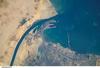 The Port of Suez - here viewed from the International Space Station - is located in Egypt along the northern coastline of the Gulf of Suez. The port and city are the southern terminus of the Suez Canal that transits through Egypt and debouches into the Mediterranean Sea near Port Said. The port serves vessels transporting general cargo, oil tankers, and both commercial and private passenger vessels. Several large vessels are visible in the Gulf of Suez and berthed at various docks around the port. Photo courtesy of NASA.