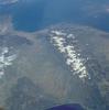 View of the Pyrenees Mountains between France and Spain taken April 1985. The snow-covered mountains, which form a formidable physical barrier between France to the north (left) and Spain to the south (right), are the main focus of this low-oblique, southeast-looking photograph. Scarcely interrupted by accessible passes and pierced in only two places by railroad tunnels, the Pyrenees are an ideal natural boundary between the Iberian Peninsula and the rest of Europe. The northern flank of the Pyrenees is characterized by a series of large alluvial deposits that fan out across southwestern France. The darker, roughly triangular area in southwest France is part of the forested Aquitaine Basin. The southern flank of the Pyrenees (Spain) is characterized by aridity and very rugged, mountainous conditions. Human settlement is sparse throughout the Pyrenees. However, because the region is rich in mineral waters, there are dozens of mineral water resorts, and winter sports attract visitors from southwestern France. The very small mountainous country of Andorra (not distinguishable in this photograph) has survived in an inaccessible upper valley of the Pyrenees. Image courtesy of NASA. 
